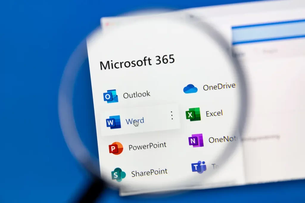 A magnifying glass hovers over a computer screen displaying Microsoft 365 apps, highlighting popular Microsoft 365 icons such as Outlook, Word, Excel, PowerPoint, and others on a white background.